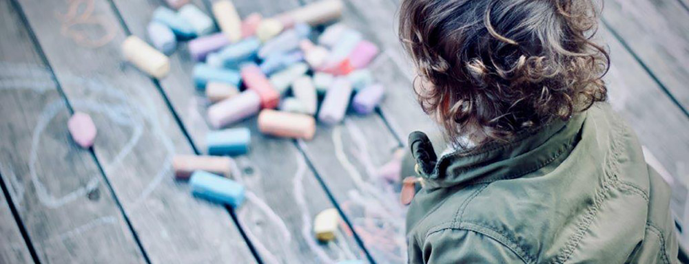 Banner image of boy looking at colour bricks on the floor